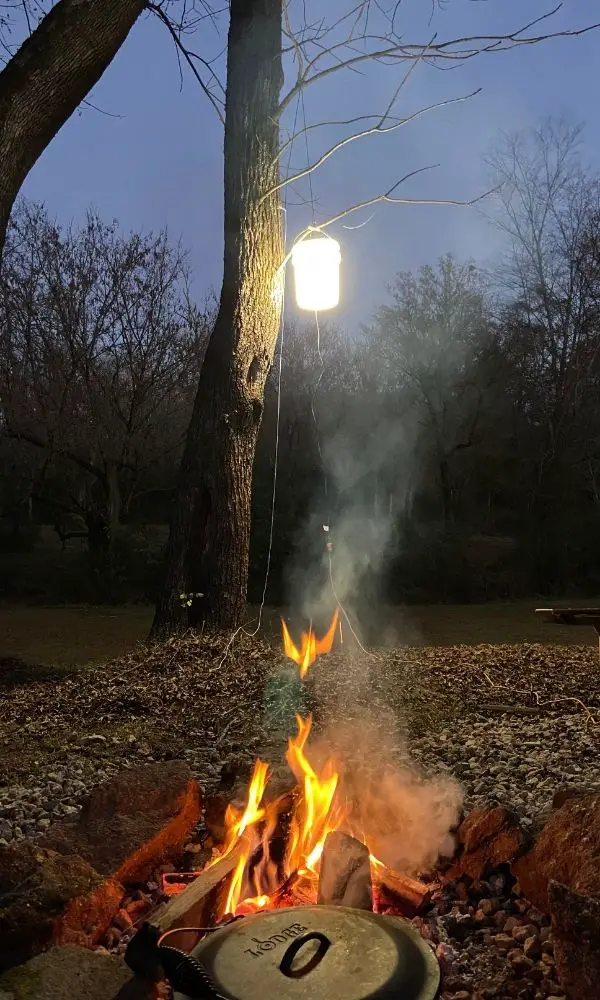 bucket light lit up above campfire