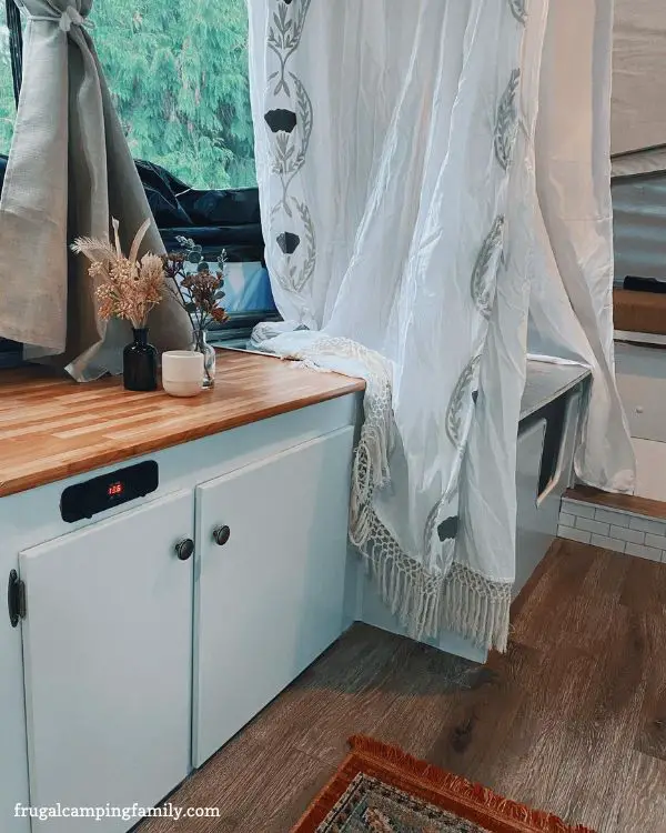 butcher block counter and white shower curtain in camper reno