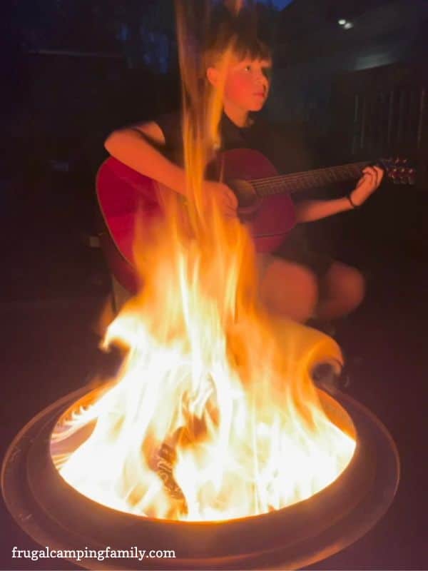 Boy playing guitar by the campfire