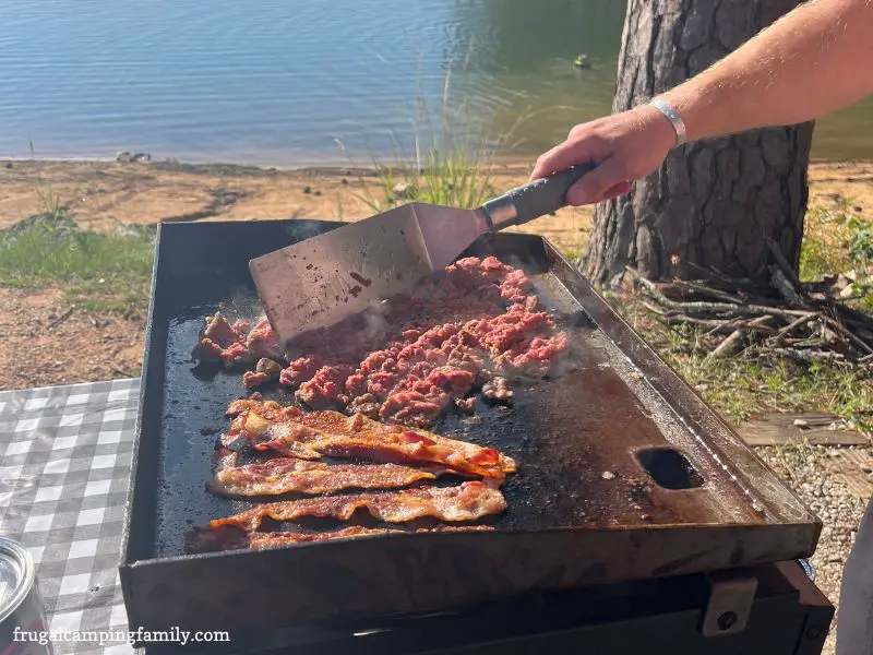 bacon and sausage cooking on a griddle