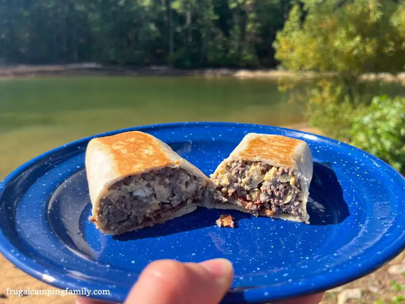 breakfast burrito cut in half on a blue camping plate