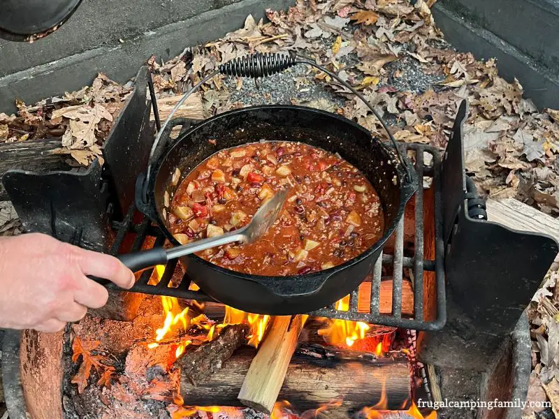 camping chili in dutch oven over a campfire