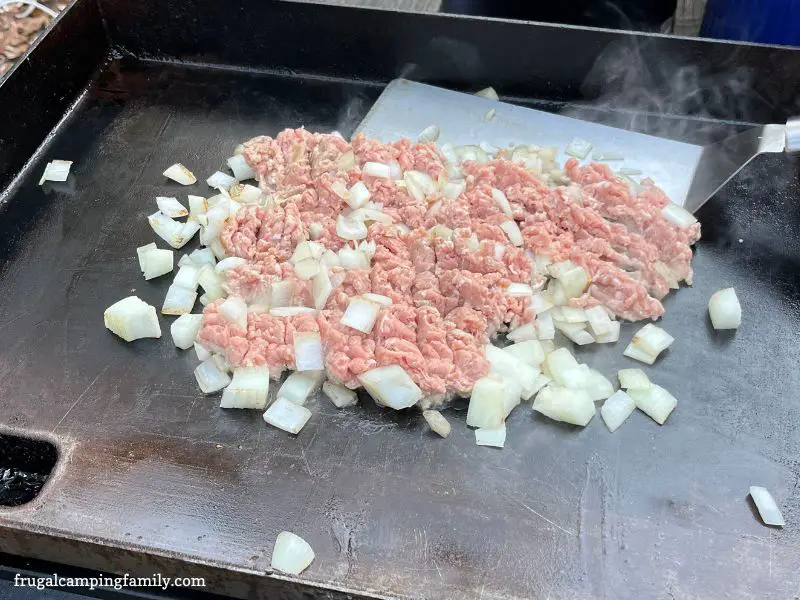 browning meat and onion on a griddle